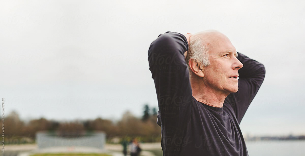 A light-skinned person holds their hands behind their head as if resting and peacefully taking in the scenery. They have light skin and white hair.