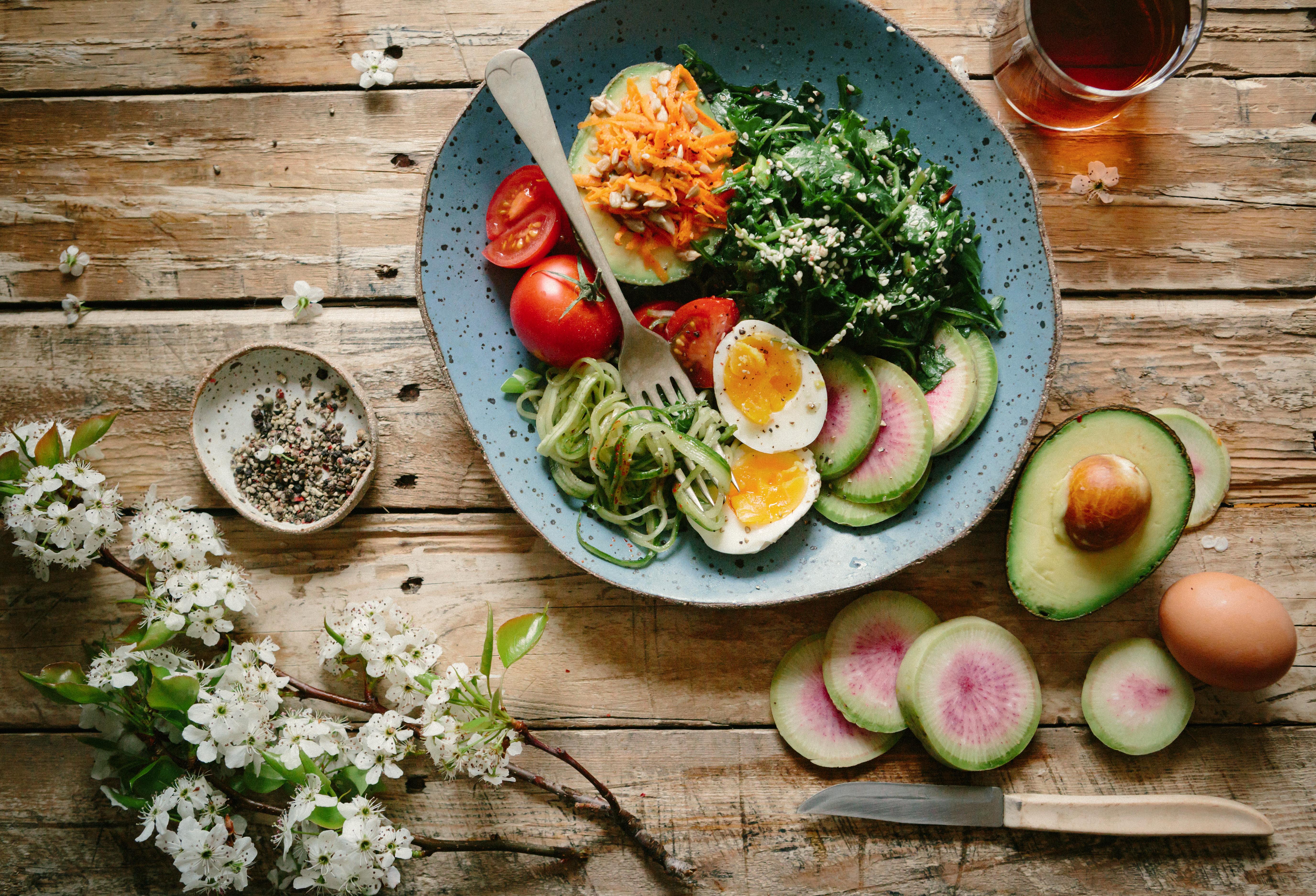 A healthy salad with boiled eggs, radishes, and tomatoes, on a plate.